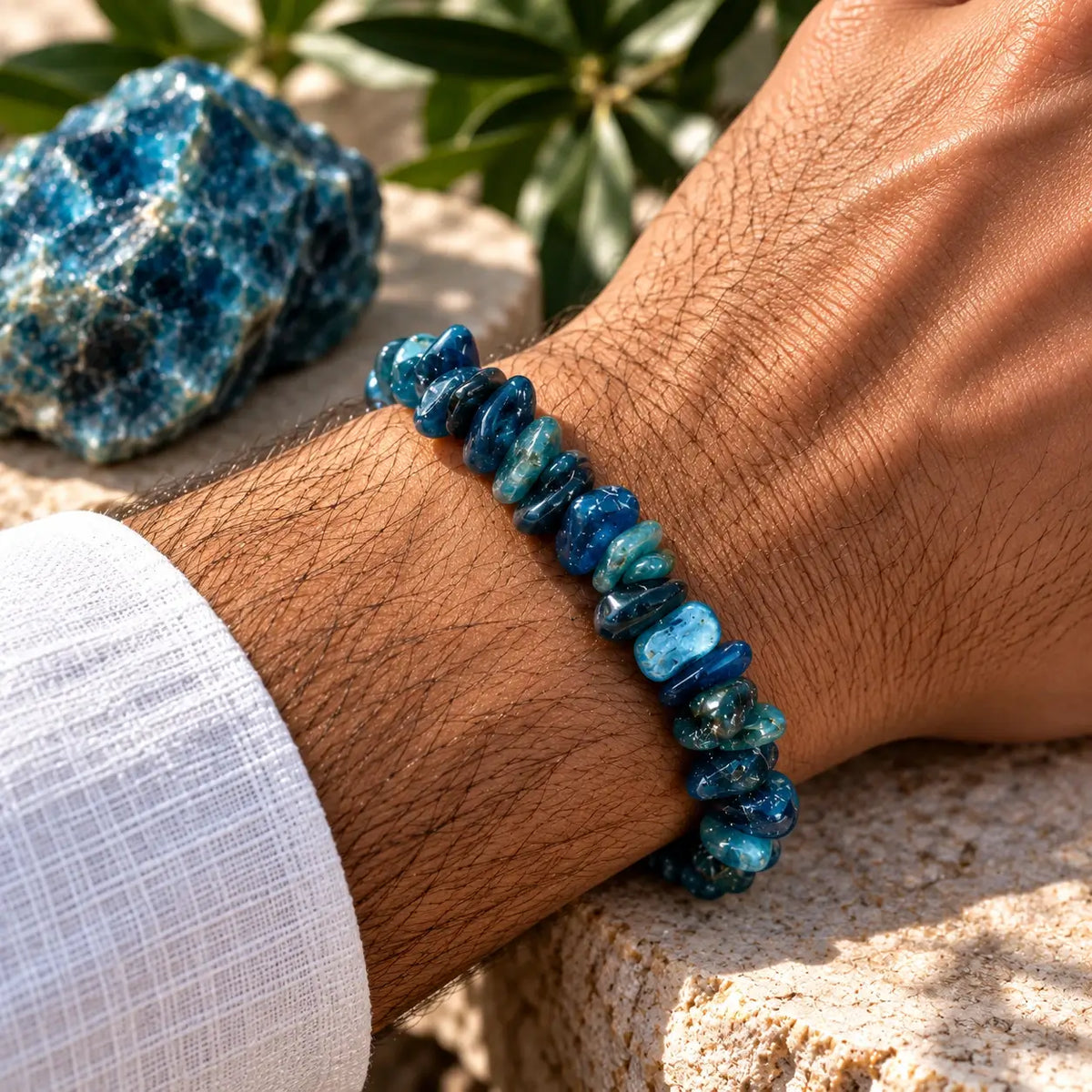 Bracelet en apatite bleu profond et bleu-vert porté au poignet avec une manche claire
