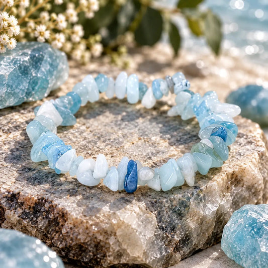 Bracelet en aigue-marine posé en cercle sur une pierre, détail des perles chips bleu clair