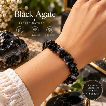 Bracelet en agate noire porté au poignet avec une manche blanche