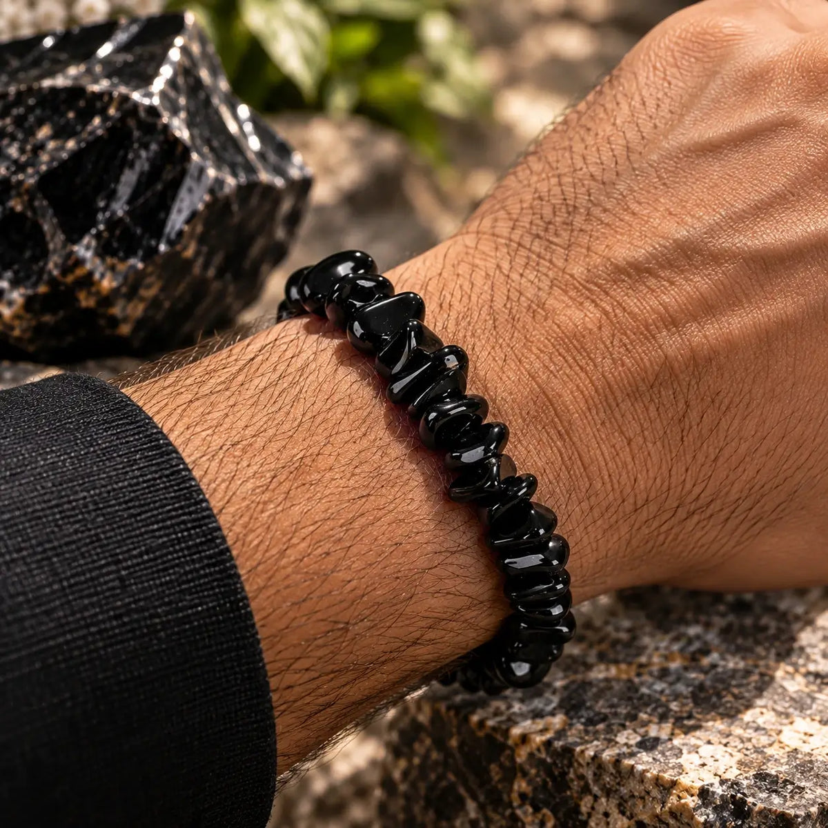 Bracelet en obsidienne noire porté au poignet avec une manche noire
