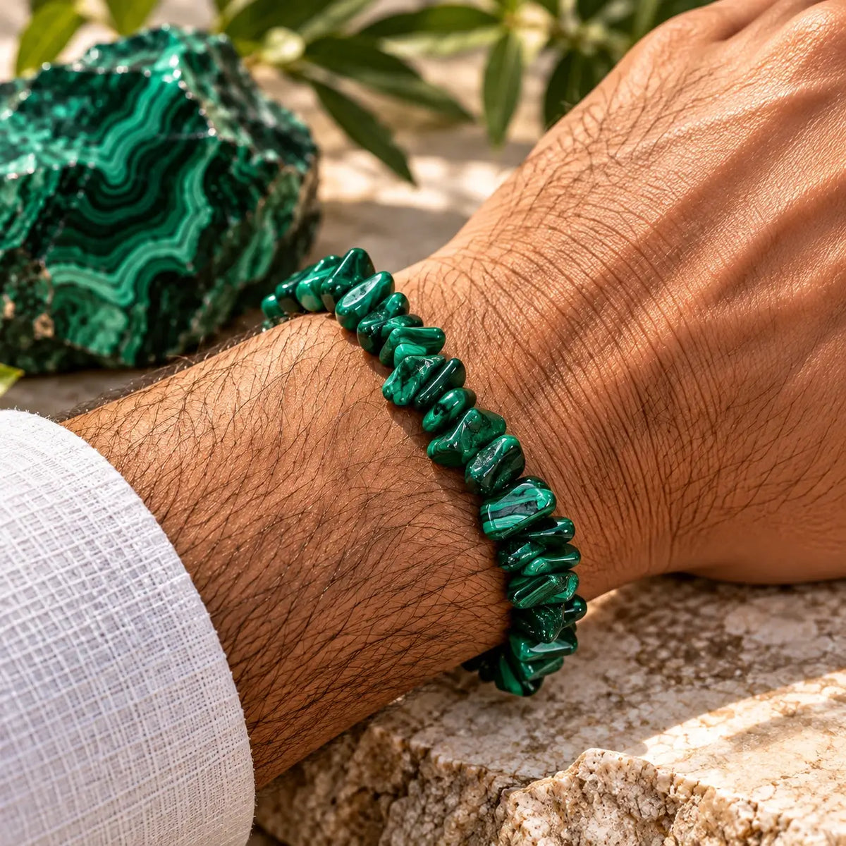 Bracelet malachite en éclats verts porté au poignet avec une chemise blanche