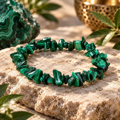 Bracelet malachite verte en éclats polis posé sur un support minéral beige