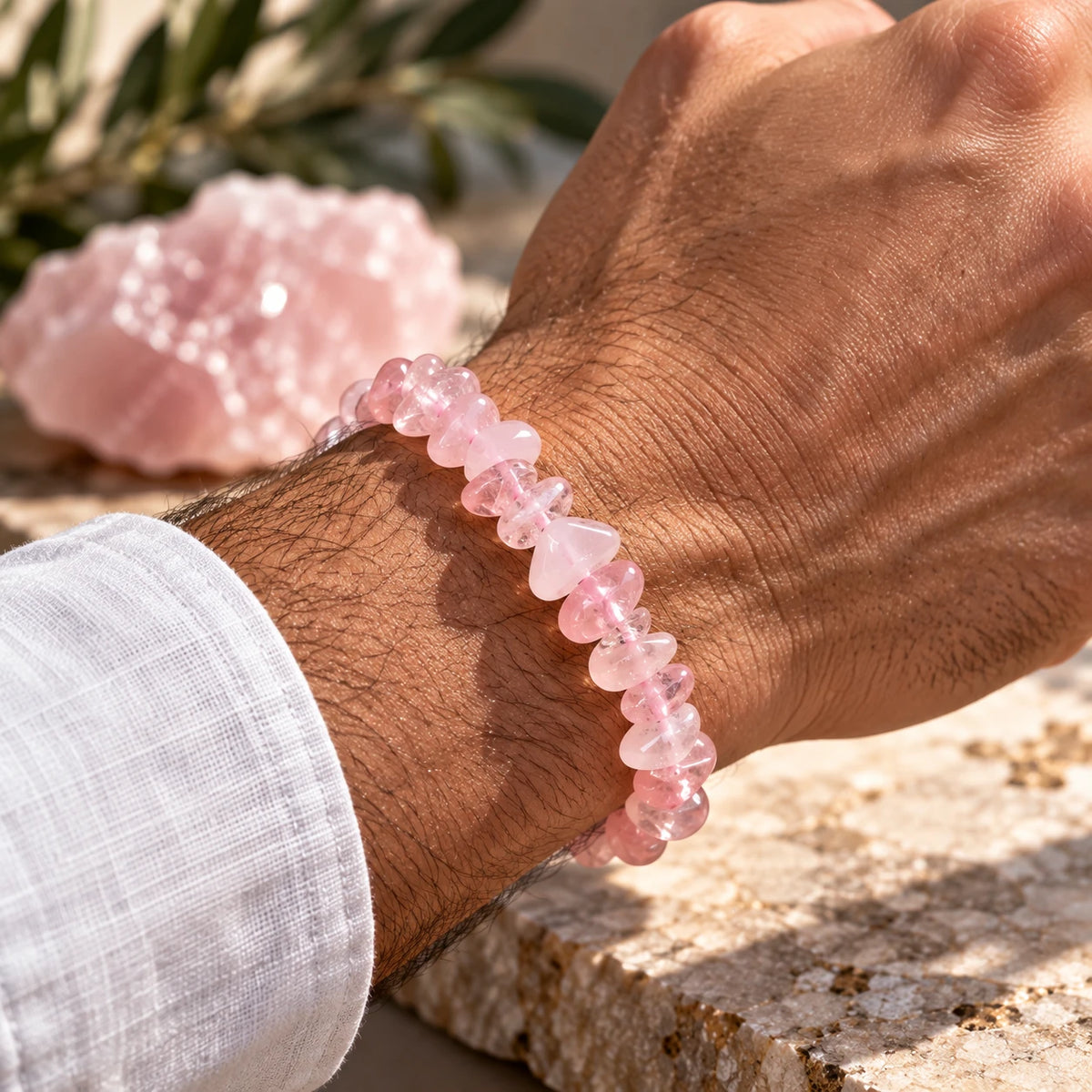 Bracelet Cristal rose porté au poignet avec une manche de chemise blanche