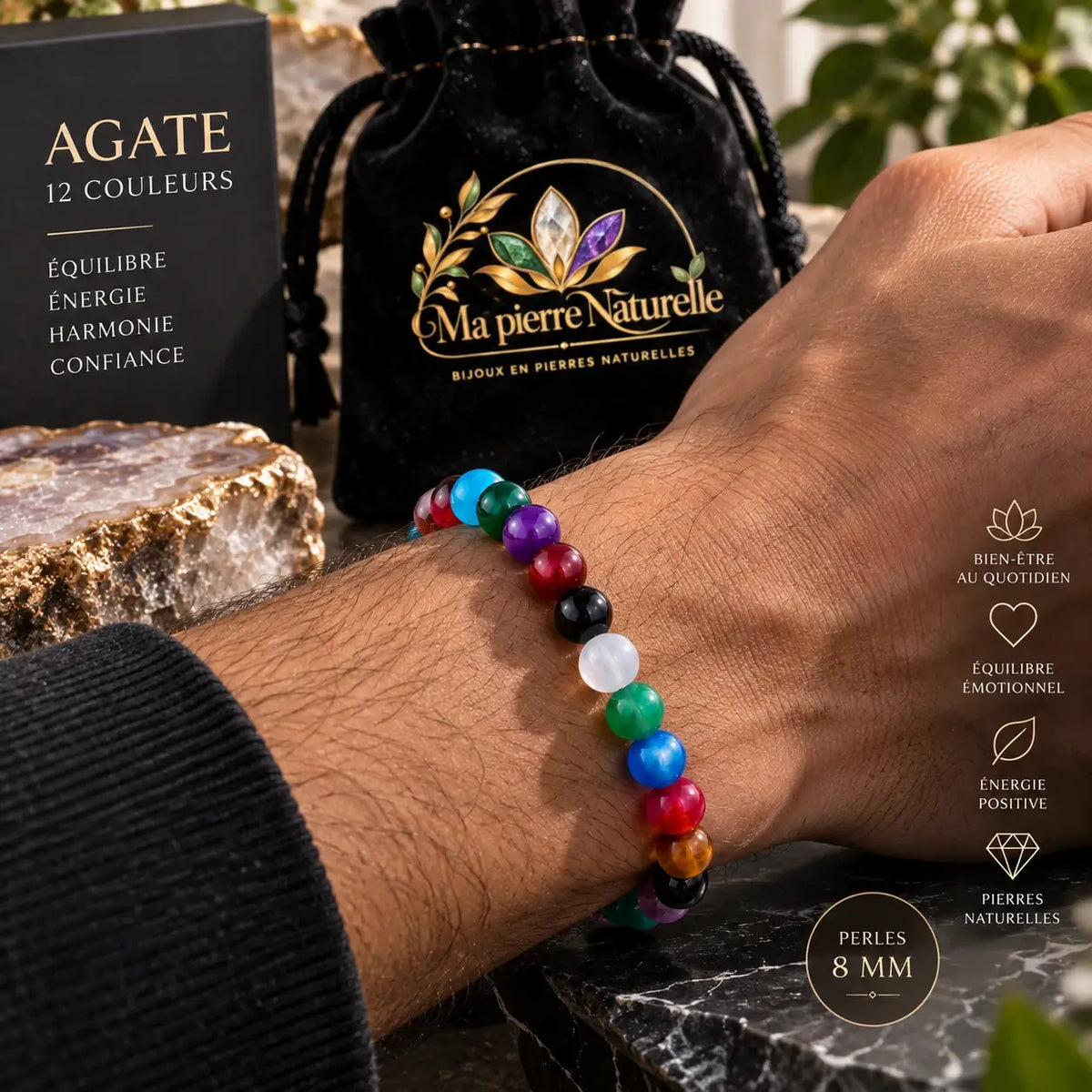 Bracelet en agate multicolore de 8 mm porté au poignet avec une manche foncée.