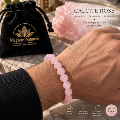 Bracelet en calcite rose de 8 mm porté au poignet avec une manche foncée.