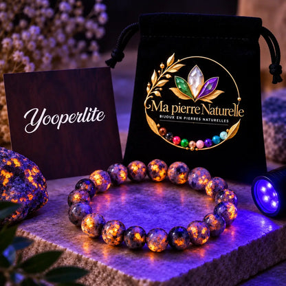 Bracelet Yooperlite aux perles présentant une fluorescence orange sous une lumière UV.